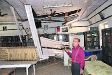 Principal of Government Degree College, Bhaderwah, points towards the damaged ceiling of a classroom. 