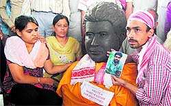 Partha Baruah (R), an artist from Assam, presents Sarabjit's bust to his daughter Swapandeep in Amritsar on Friday