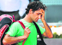 A dejected Roger Federer leaves the court after being defeated by Kei Nishikori 6-4, 1-6, 6-2 in the third round of the Madrid Open. 