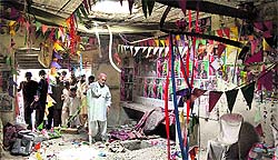 People at the site of an election campaign office of the PPP which was destroyed by a blast in Quetta