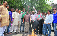 Members of the Doon Auto Rickshaw Union burn the effigy of the State Transport Authority against the inadequate increase in passenger fares in Dehradun on Saturday. 