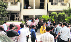 People look at the Ardee City building where a Delhi Police Special Cell Inspector and his woman friend were found dead in Gurgaon on Saturday. Tribune photo: Sayeed Ahmed
