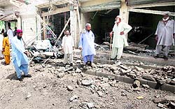 Residents gather at the site of a bomb attack near a polling station in Karachi on Saturday