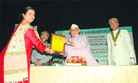 Governor Aziz Qureshi presents an award of excellence to a woman in Dehradun on Sunday