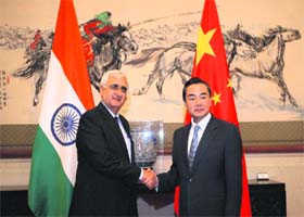 External Affairs Minister Salman Khurshid shakes hands with his Chinese counterpart Wang Yi during a meeting in Beijing, China, on Thursday