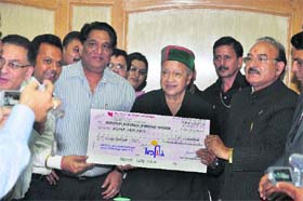 Himachal Drug Manufacturers Association members present a cheque for Rs 11 lakh to Chief Minister Virbhadra Singh