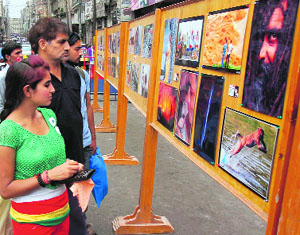 Visitors look at pictures on display at the Ashok Sodhi memorial exhibition in Jammu on Sunday.  