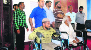 Physically challenged persons who were given wheelchairs by the Red Cross Society in Rajouri on Sunday . 