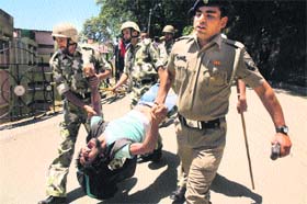 Police personnel and commandos arrest a student during a clash between SFI and ABVP activists at the HPU in Shimla on Monday