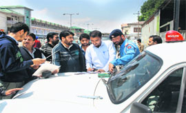  Traffic policemen penalise drivers for violating traffic rules in Srinagar on Monday.