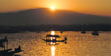 A man paddles his boat at sunset on the Dal Lake in Srinagar on Monday.