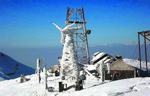 A conventional wind turbine in the Himalayas is seen under snow accumulation during winter.