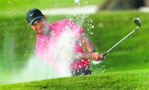 Tiger Woods hits out of a sand trap on the 16th hole during the final round of The Players Championship PGA golf tournament at TPC Sawgrass on Monday.