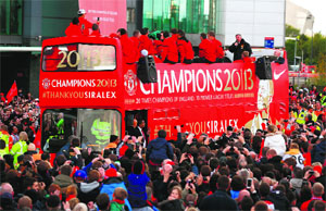 Retiring Manchester United manager Alex Ferguson speaks to the crowd from the rear of a double decker bus during the soccer team's English Premier League victory parade outside Old Trafford stadium in Manchester on Monday.
