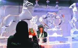 A woman photographs her husband at an ice loungein UAE, which has carved ice and frozen sculptures, on Sunday