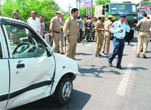 Policemen clear a traffic jam after a car was hit by a vehicle on the flyover near the Civil Secretariat in Jammu on Tuesday.