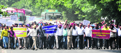 Shopkeepers form a human chain on Ferozepur Road leading to snarl-ups in Ludhiana on Tuesday.