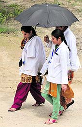 Girls use umbrella to escape harsh sun-rays as the temperature crossed 40 degree mark, at the Adesh University near Bhucho
