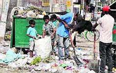 Children rummage through garbage bin in a city locality