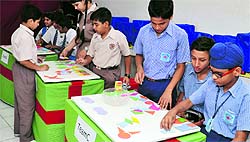 Students look at the model of an aeroplane during the NCC enrolment campaign at Government Model Senior Secondary School in Sector 20; and (right) students take part in an inter-school mathematics and computer event at St Xaviers Senior Secondary School, Sector 44-C, Chandigarh, on Wednesday