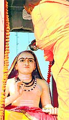 A saint offers milk at the idol of Adi Jagadguru Shankaracharya on the latters birth anniversary in Haridwar on Wednesday