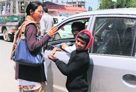 A boy seeks alms from a tourist on the Residency Road in Srinagar on Wednesday. 