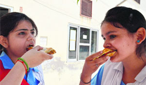Girls relish fast food at a school in Ludhiana. 