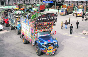 Trucks from Pakistan-occupied Kashmir wait to unload material at Salamabad in the Uri area of Baramulla district. 