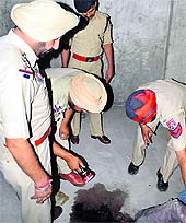 Policemen inspect the spot where the victim's body was found in Ludhiana on Thursday