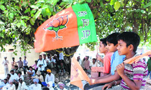 Children with BJP and SAD flags at an election meeting at Urdan village near Rajpura on Tuesday. 
