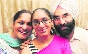Simardeep Kaur Juneja, a student of the humanities stream, with her parents in Moahli on Friday. 