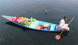 A flower vendor rows his boat in the Dal Lake in Srinagar on Friday. 