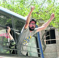 A protester shouts a slogan against the state government while he was being taken to a Bathinda court on Saturday. 
