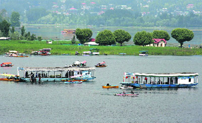 Tourists enjoy boating on the Dal Lake in Srinagar on Saturday.