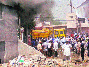 Residents gather outside the grocery shop that caught fire in Mandi Gobindgarh on Saturday.