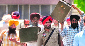 Staff on the election duty carry ballot boxes to Guru Nanak Dev Bhawan in Ludhiana on Saturday. 