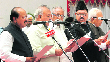 Newly inducted ministers take oath during a ceremony at Raj Bhawan in Bangalore on Saturday.