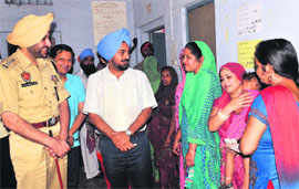 Mohali Deputy Commissioner Tejinderpal Singh Sidhu (in blue turban) and Senior Superintendent of Police GS Bhullar interact with women voters at Kumbhra village during the Zila Parishad and Panchayat Samiti elections in Mohali on Sunday. 