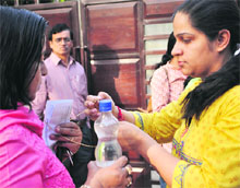 A woman candidate removes her chain before entering the exam hall at a school in Sector 15, Chandigarh, on Sunday. 
