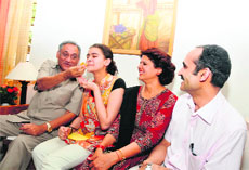 Chief Minister Vijay Bahuguna offers sweets to ISCE topper Bhuvanya Vijay at her residence in Dehradun on Sunday.