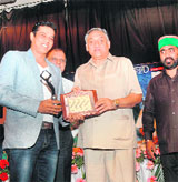 Chief Minister Vijay Bahuguna presents an award to 