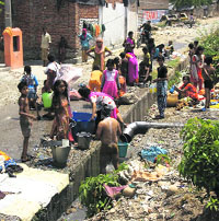 Residents draw water from supply pipes. 