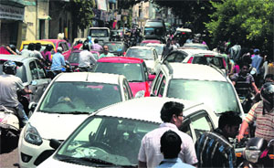 A traffic jam on the road in Kachchi Chawni of Jammu after hundreds of examinees came out after appearing in an entrance test for postal assistance at Government College Parade on Sunday