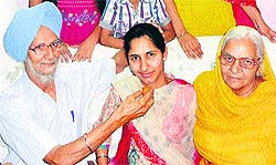 Kirandeep of class XII who has stood second in the state in the non-medical stream by securing 421 out of 450 marks with her proud family members