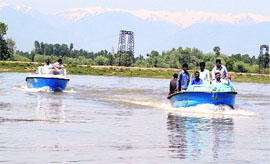 Officials of the police and civil administration during a search operation in the Jhelum river in Sopore.