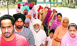 Voters queue up at a poling booth at Pohir village, near Ahmedgarh, on Sunday