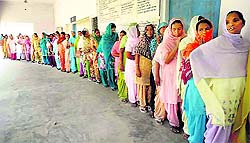 Women wait for their turn to cast vote at Khatran village in Samrala subdivision