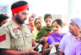 A policeman checks identity cards of voters at a polling booth in Amritsar on Sunday.