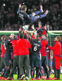 PSG players throw David Beckham in the air at the end of their match against Brest on Saturday. Beckham broke down in tears during his last match.