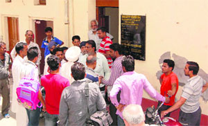 Residents of Parasram Nagar stage a protest against a depot holder in Bathinda on Monday. 